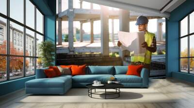 portrait of male site contractor engineer with hard hat holding blue print paper Wall mural