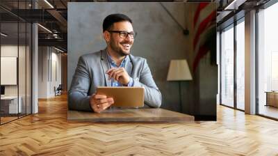 Portrait of young business man working on digital tablet Wall mural