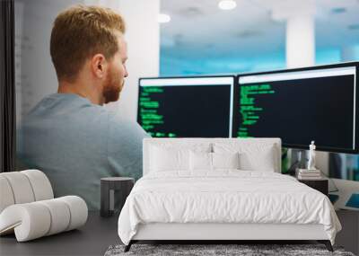 Portrait of young programmer working in office Wall mural