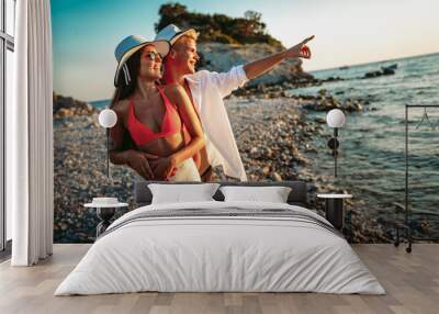 Romantic couple in love walking on beautiful beach on vacation Wall mural