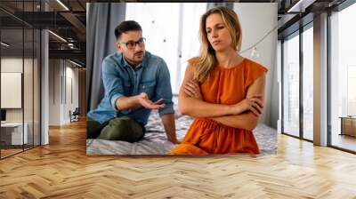 Sad pensive couple thinking of relationships problems sitting on sofa, conflicts in marriage. Wall mural