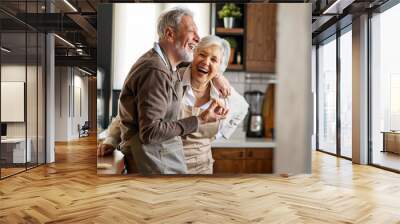 Senior happy couple in love smiling in kitchen Wall mural