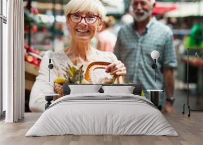 Senior shopping couple with basket on the market. Healthy diet. Wall mural