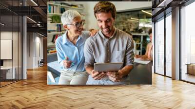 Smiling diverse colleagues gather in boardroom brainstorm discuss financial statistics together Wall mural