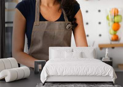 Sporty young woman is preparing healthy food in kitchen Wall mural