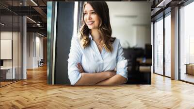 Successful business woman looking confident and smiling Wall mural