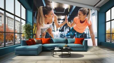 Two sporty girls doing push ups in gym Wall mural