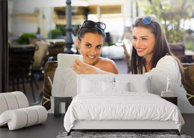 Two young beautiful women taking a selfie of themselves Wall mural