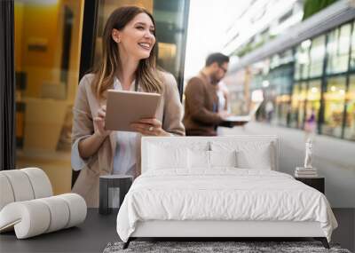 Urban happy business woman using tablet computer and working Wall mural