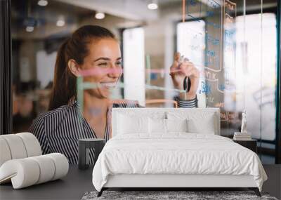 Woman working and writing on the glass board in office. Business, technology, research concept Wall mural