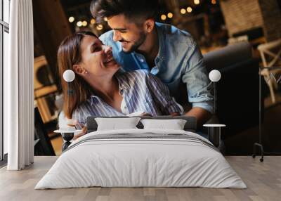 Young attractive couple on date in coffee shop Wall mural