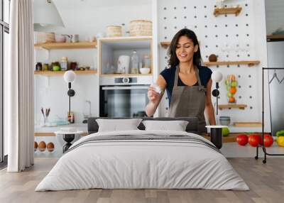 Young beautiful woman cooking healthy food in the kitchen. Healthy lifestyle, food, diet concept Wall mural