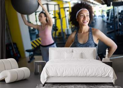 Young beautiful woman doing exercises with personal trainer Wall mural