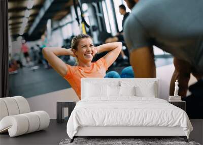 Young beautiful woman doing exercises with personal trainer Wall mural