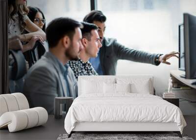 Young businesspeople working on computer in office Wall mural