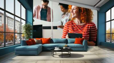 Young businesswoman leading a discussion during a meeting with her colleagues. Wall mural