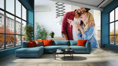 Young couple unpacking cardboard boxes at new home moving in concept Wall mural