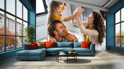 Young family being playful at home. People parent child fun happiness concept. Wall mural