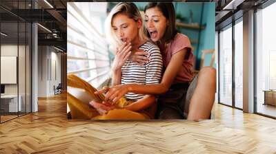 Young female friends surfing the internet and having fun together Wall mural