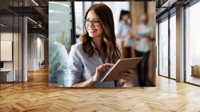 Young happy business woman working with tablet in corporate office Wall mural