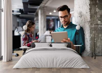 Young man using technology, digital tablet in corporate business office Wall mural