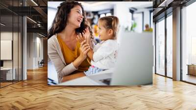 Young mother with child working from home office Wall mural