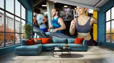 Young people running on a treadmill in modern gym Wall mural