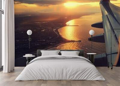 Golden Hour Departure: Soaring above the clouds, a plane wing frames a breathtaking sunset over a coastal city bathed in warm, golden light.  Wall mural