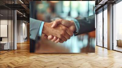 Close-up of two businessmen shaking hands in a professional setting.  The image represents partnership, agreement, and success. Wall mural