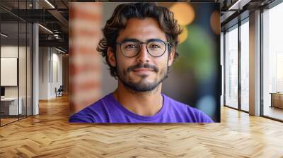 A confident young hispanic man in a purple shirt and glasses exuding professionalism and style. Wall mural