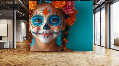 A joyful young girl with intricately painted day of the dead face makeup and a vibrant flower crown celebrates the festive and colorful tradition of the Day of the Dead. Wall mural