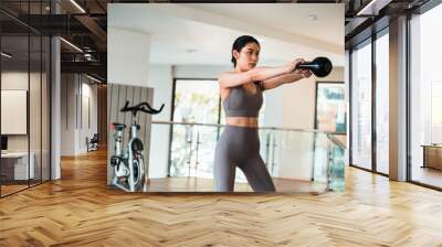 Beautiful young  women are working out  in the gym with kettlebell Wall mural