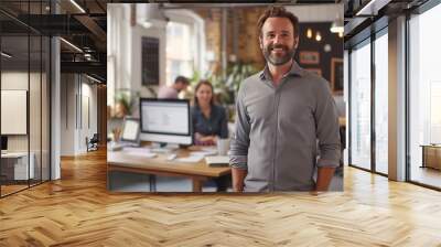 Portrait of a smiling young businessman standing in his trendy office  Wall mural