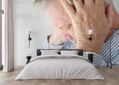 stressed older man holds his head in both hands Wall mural