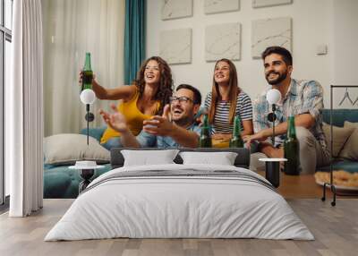 Group of young friends having fun while drinking beer at home Wall mural