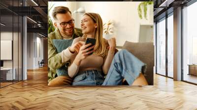 Overjoyed young couple triumph celebrate read good unexpected news on smartphone. Wall mural