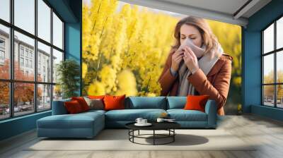 A woman standing in a field of yellow flowers blowing her nose created with Generative AI technology Wall mural