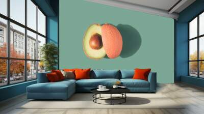 Pink and green avocado cut in half on a pastel background. Unhealthy eating minimal concept. Wall mural