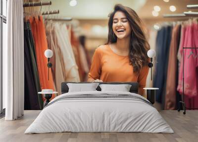 Young indian girl shopping and standing at cloth store Wall mural