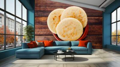 Plate with arepas on a rustic wooden background Wall mural