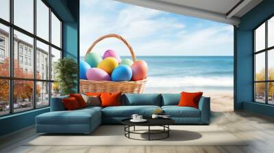 Painted easter eggs in wicker basket at the sand sea beach. Copy space Wall mural