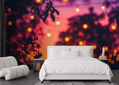 A lively outdoor evening event with colorful string lights, bokeh effects, and a stunning sunset in the background. Wall mural