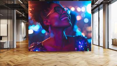 A young woman sporting curly hair and stylish glasses is having a great time at a lively party atmosphere Wall mural