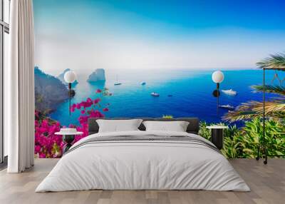 Famous Faraglioni cliffs and Tyrrhenian Sea clear blue water, Capri island, Italy with flowers, web banner format Wall mural