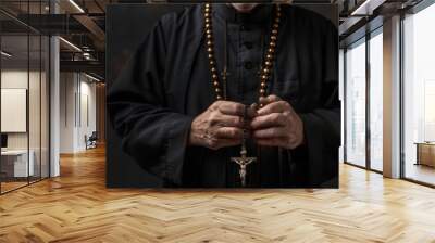 Image of a priest's hands holding rosary beads, symbolizing faith, devotion, and religious commitment. Wall mural