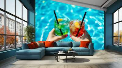 An image of friends toasting with colorful drinks on the beach, with a close-up of their hands and glasses filled with colorful cocktails Stock Wall mural