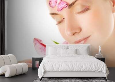 Beautiful young woman with pink lily close-up portrai Wall mural