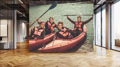 Cheerful friends taking selfie in kayaks on a beach. Wall mural