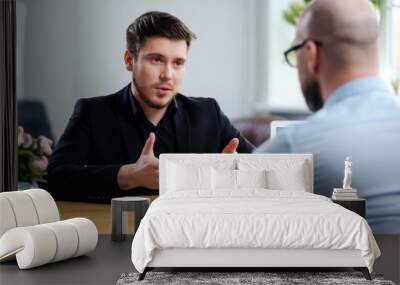 Confident young man attending job interview Wall mural