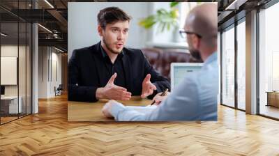 Confident young man attending job interview Wall mural